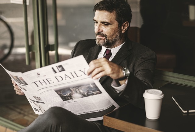 muž s kávou a novinami